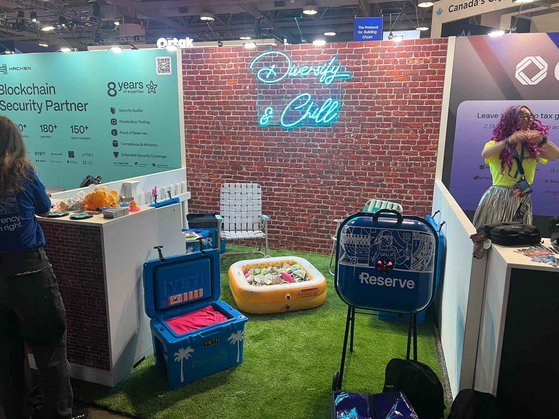 The Reserve booth: turf, lawn chairs, a kiddie pool, a grill and a lit Diversify & Chill sign